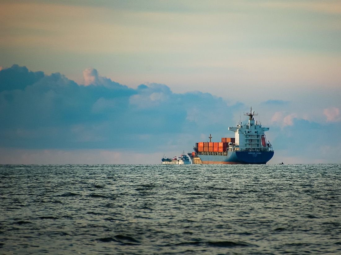 Container ship sailing on the open sea at dusk